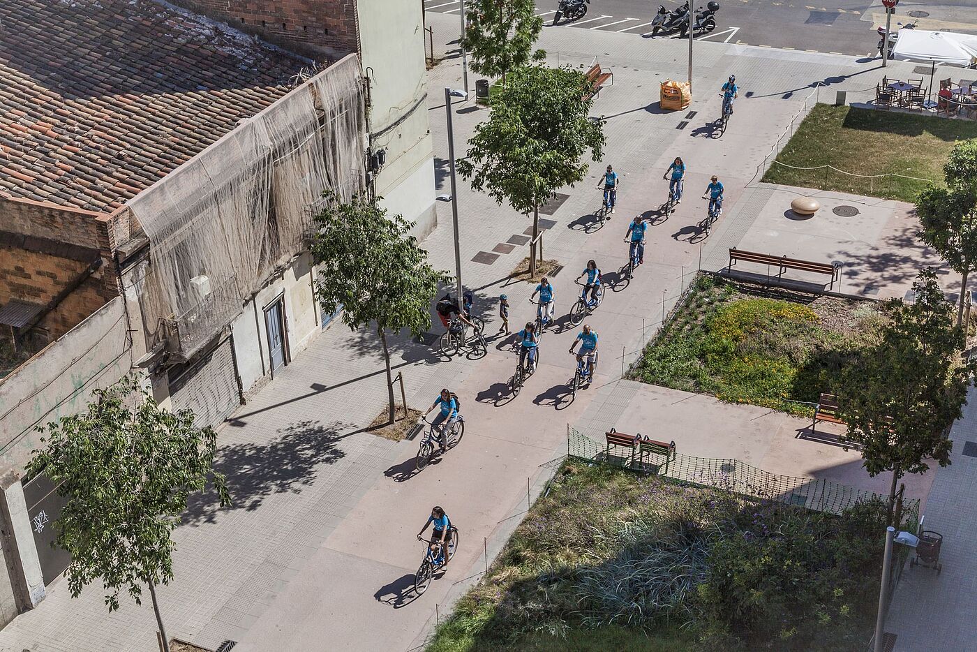 Eine Gruppe von Radfahrer*innen fährt durch einen Superblock. Sie sind aus der Vogelperspektive fotografiert. 