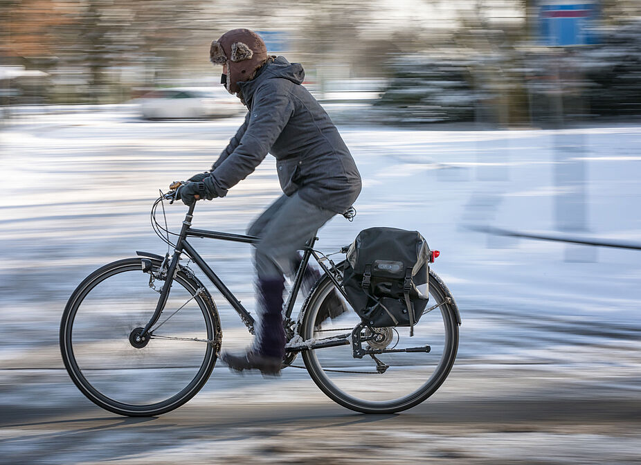 Radfahrer*in fährt auf einer ungeräumten Fahrbahn Radfahrer*in fährt auf einer ungeräumten Fahrbahn