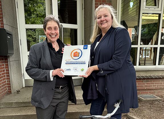 Stephanie Meyer (l.), Landesvorsitzende ADFC SH, übergibt Plakette an Schulleiterin Birgit von Glahn (r.)