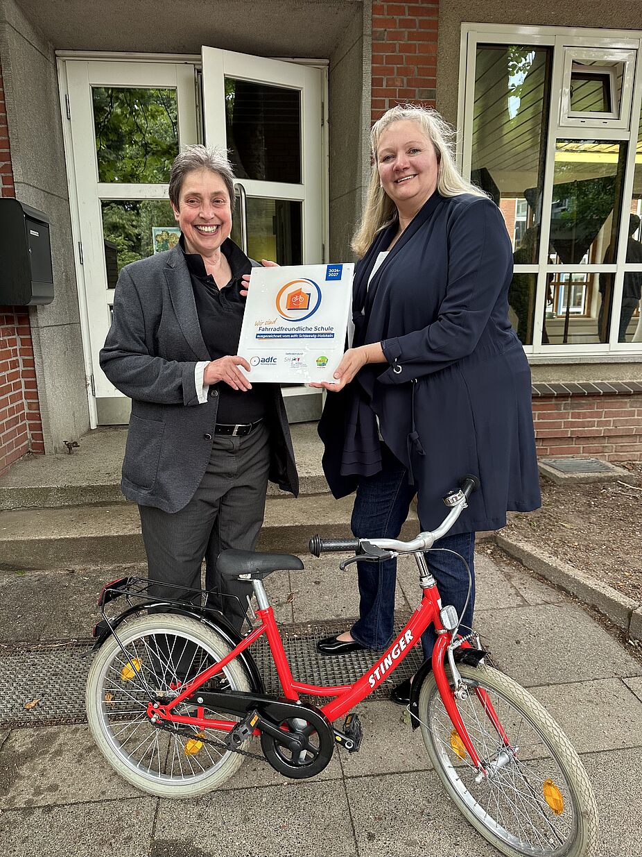 Stephanie Meyer (l.), Landesvorsitzende ADFC SH, übergibt Plakette an Schulleiterin Birgit von Glahn (r.) Stephanie Meyer (l.), Landesvorsitzende ADFC SH, übergibt Plakette an Schulleiterin Birgit von Glahn (r.)