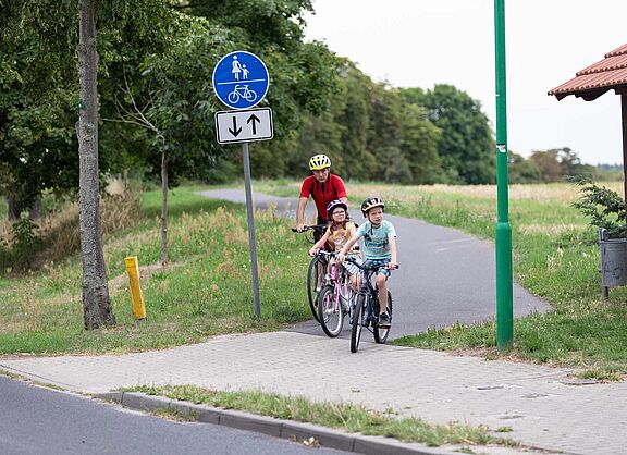 Opa mit Enkelkindern auf Radweg 