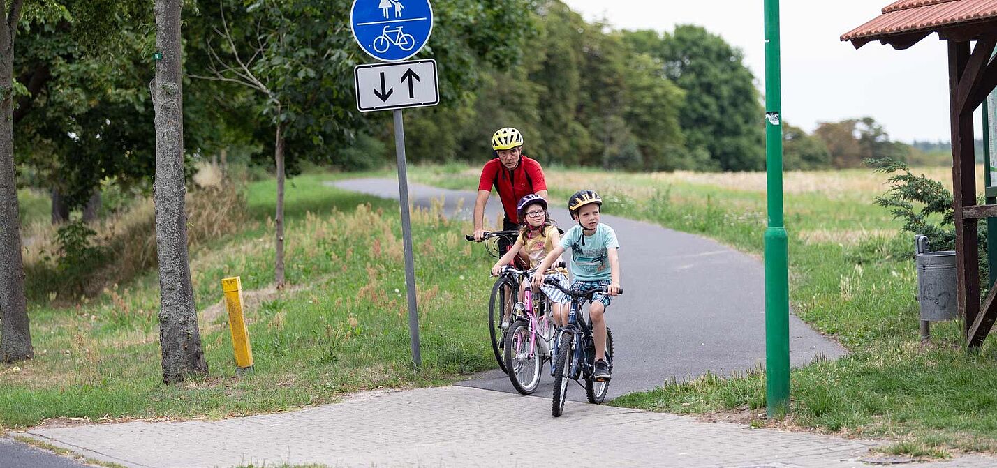 Opa mit Enkelkindern auf Radweg 